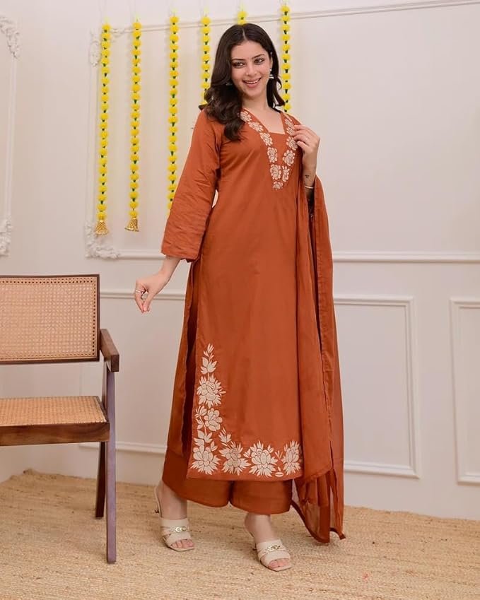 Woman wearing a rust orange embroidered kurta with matching dupatta, posing against a plain background.