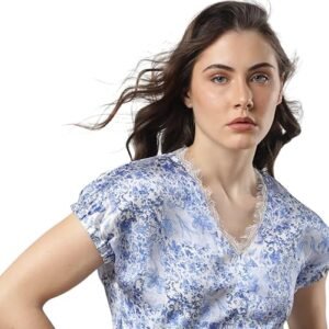 Woman wearing a blue floral print V-neck top with short puff sleeves, posing against a white background.