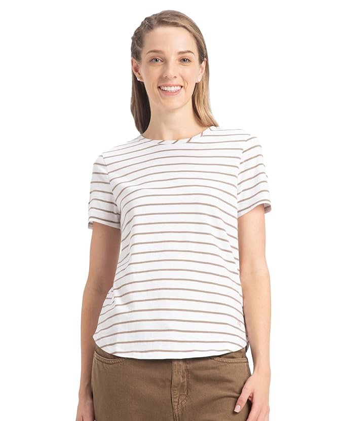 Woman wearing a white striped short-sleeve t-shirt paired with brown pants against a plain background.