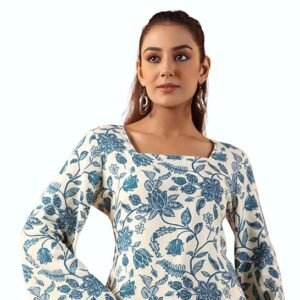 Woman wearing a white and blue floral printed tunic top with bell sleeves and black pants